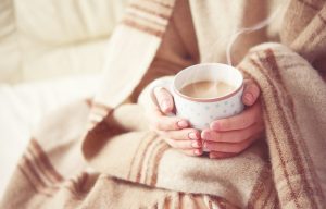 warm blanket wrapped around a person holding a mug